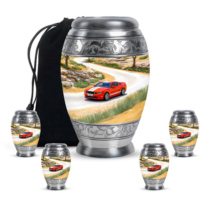 Sunrise Gold Car Cremation Urn detail view - ornate monarch-style car relief on brushed aluminum - memorial set with one large and four small urns