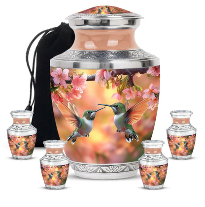 Matte Gold Hummingbird Cremation Urn lifestyle display on memorial shelf - stylized abstract hummingbird pattern with bold lines - memorial set with one large and four small urns