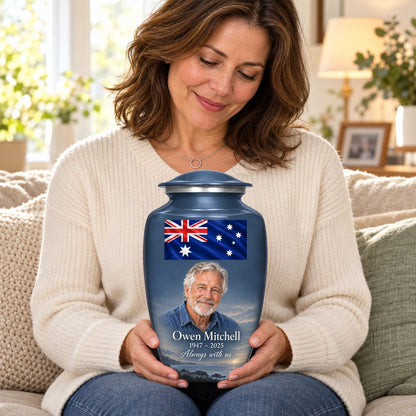 Seated person holding the slate blue adult Slate Coastal Tribute Australian flag urn on their lap.