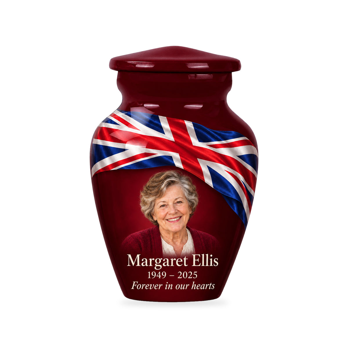 One burgundy red ringless 3-inch keepsake urn with diagonal Union Jack ribbon, a fictional sample portrait and inscription on white.