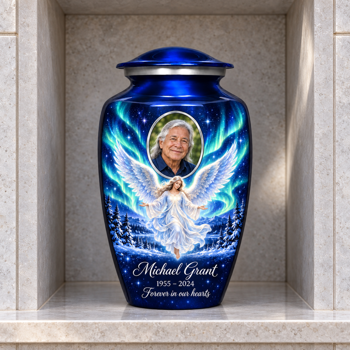 Blue adult urn with a floating angel, aurora sky, snowy trees and an oval sample portrait frame, displayed in a columbarium niche.