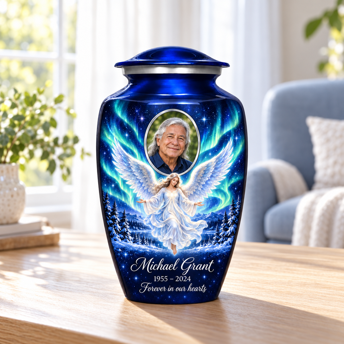 Blue adult urn with a floating angel, aurora sky, snowy trees and an oval sample portrait frame, arranged in a sunlit home.