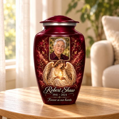 Red adult urn with a seated angel holding a candle and a rectangular sample portrait frame, displayed in a sunlit home.