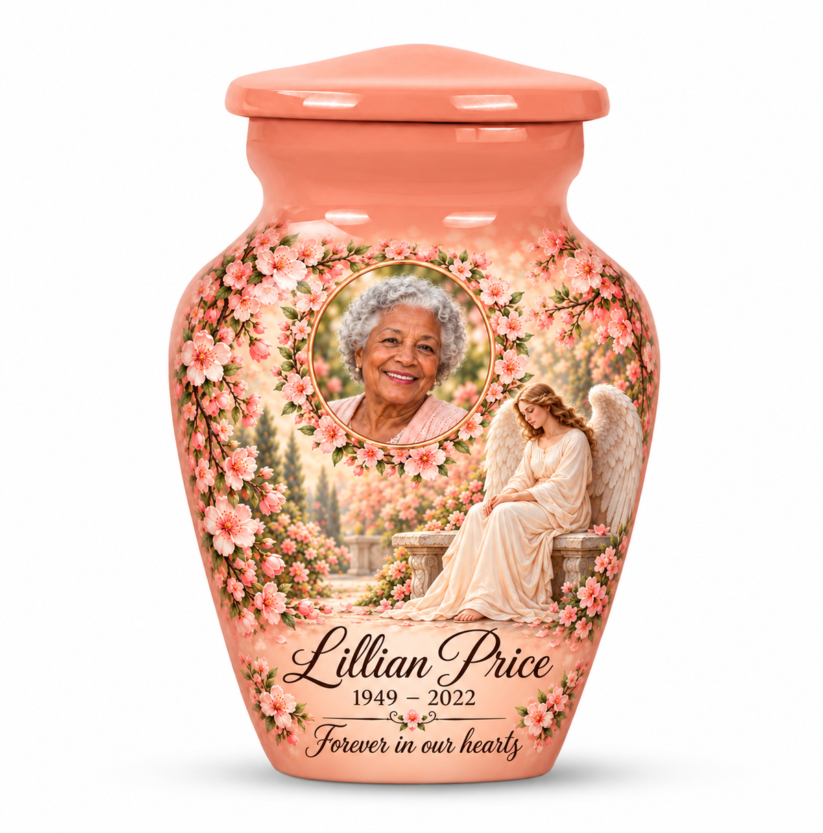 One pink angel keepsake urn with a seated angel, peach blossoms and an oval floral sample portrait frame and sample personalization.