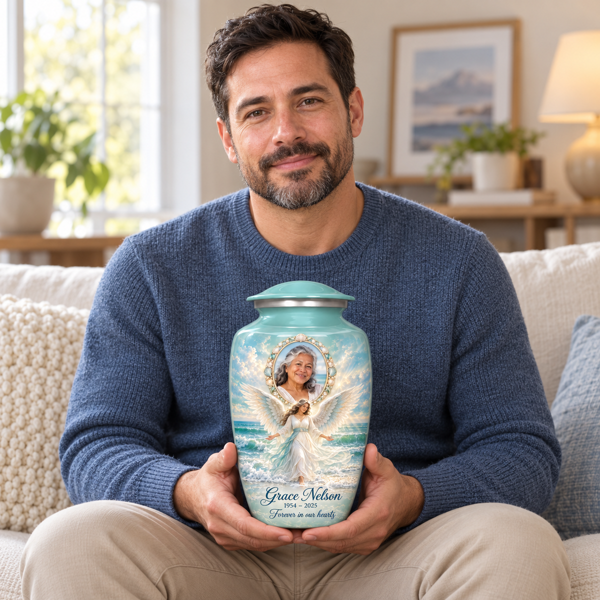 A seated person holding the blue angel urn with an ocean angel among waves and a shell style oval sample portrait frame on their lap.