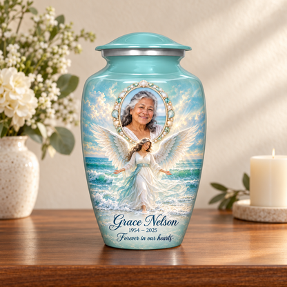 Blue adult urn with an ocean angel among waves and a shell style oval sample portrait frame, arranged on a memorial console.