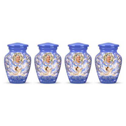 Four matching blue angel keepsake urns with sample portraits and inscriptions on white.