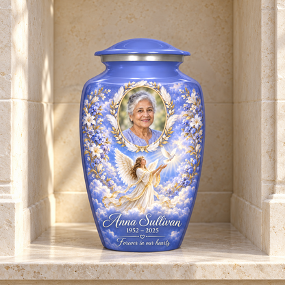 Blue adult urn with an angel releasing a dove and a feather and laurel sample portrait frame, displayed in a columbarium niche.