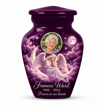 One purple angel keepsake urn with a seated angel on a crescent cloud, moonlit sky and an oval sample portrait frame and sample personalization.