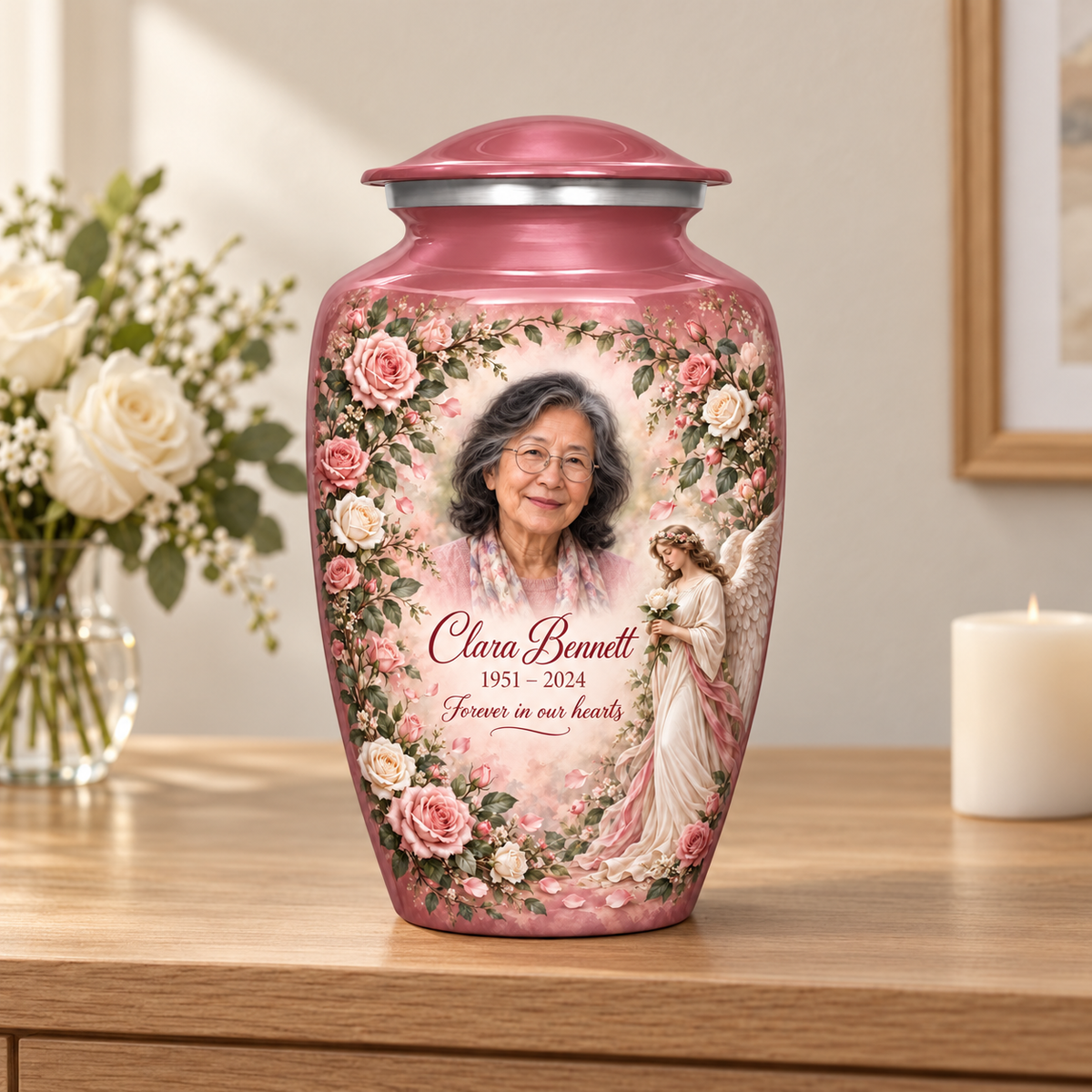 Pink adult angel urn with an angel holding a white rose amid pink flowers on a memorial console.