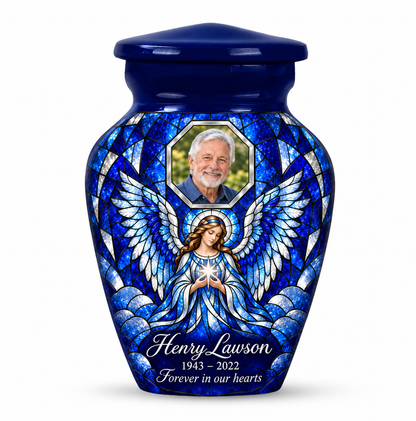 One blue angel keepsake urn with a star holding angel in mosaic inspired artwork and a geometric sample portrait frame and sample name and dates.