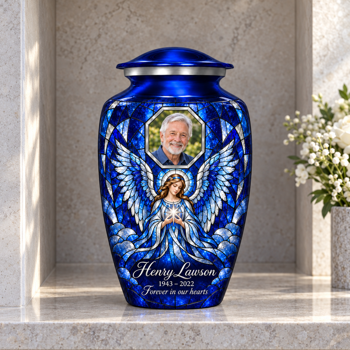 Blue adult urn with a star holding angel in mosaic inspired artwork and a geometric sample portrait frame, displayed in a columbarium niche.