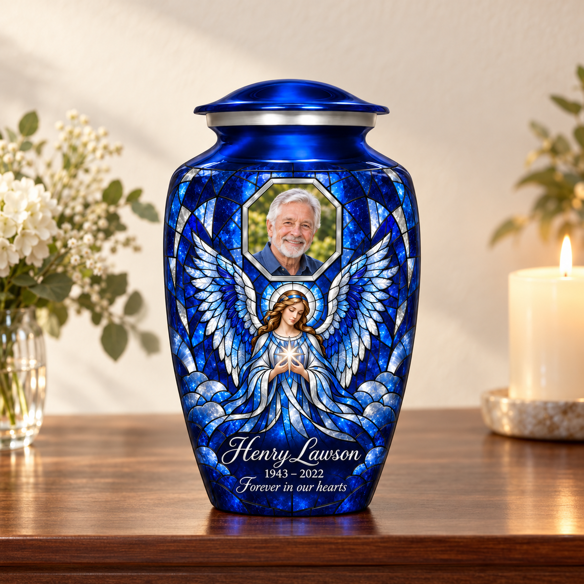 Blue adult urn with a star holding angel in mosaic inspired artwork and a geometric sample portrait frame, arranged on a memorial console.